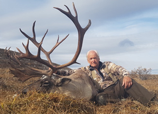 Man next to caribou in field