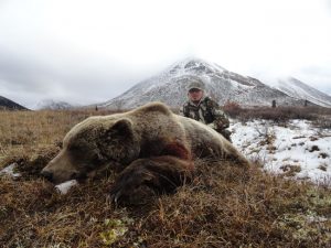 Hunter with a Grizzly Bear in the Mountains